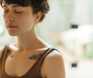 Person breathing deeply with closed eyes in a calm environment.