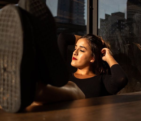 Person in a focused pose in a spacious, sunlit room.
